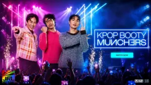 Three stylish K-pop inspired performers headline MEN.com’s “KPop Booty Munchers” in a cinematic neon concert setting with Hollywood-style stage lighting and cheering crowd.